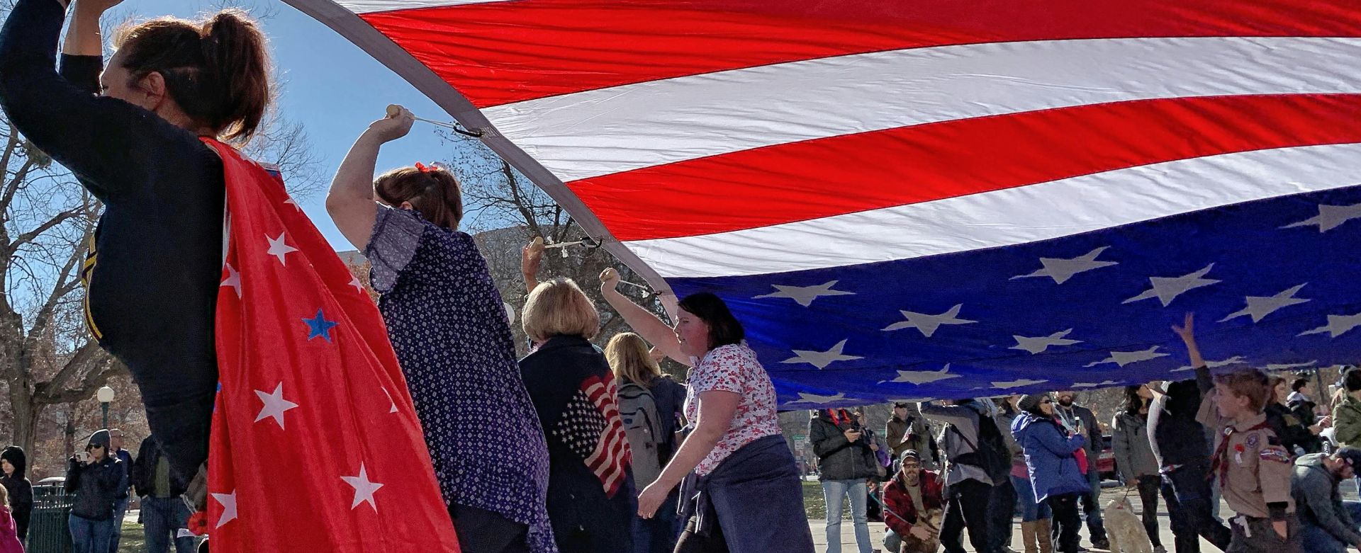 People Carrying The Flag Of America