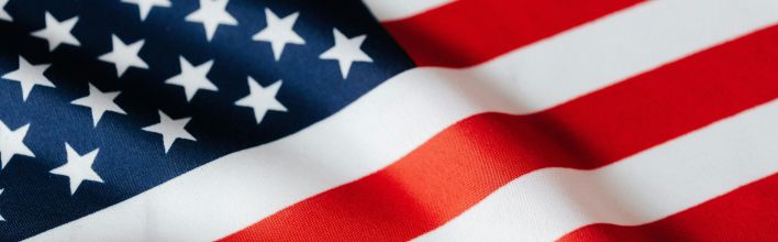 From above of closeup flattering national flag of USA with white and red stripes and stars on blue background